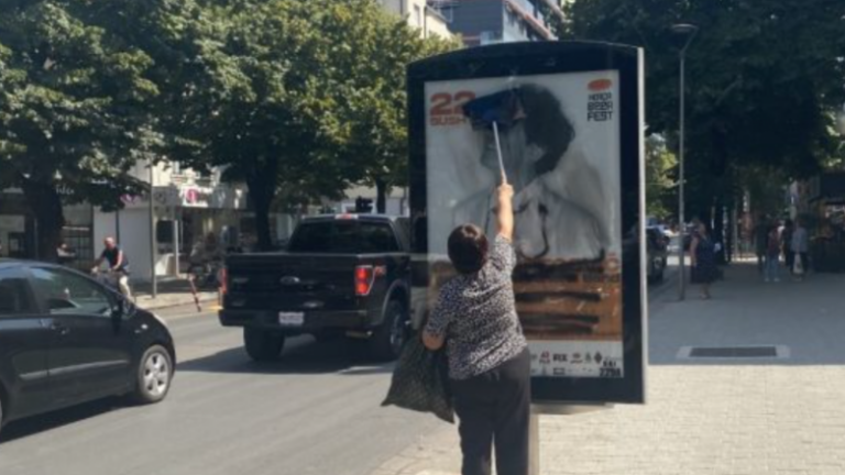 Gruaja në Tiranë pastron reklamën ku u fshi fytyra e Goran Bregovicit dhe u shkrua 1999